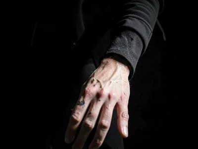 Person's hand at extreme bottom reaching toward invisible object