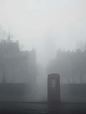 A foggy London morning: a red telephone booth as the only color anchor, everythi