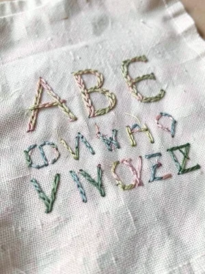 Hand-stitched ABC alphabet sampler on linen, child's learning artwork