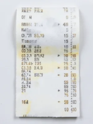 Long grocery receipt curling at the edges, thermal print half-faded, prices diss