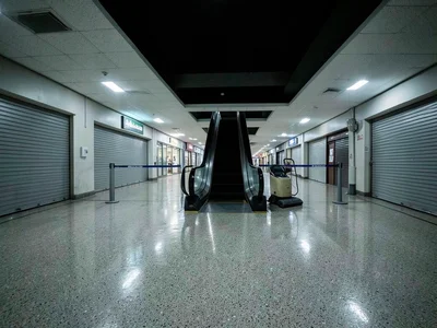 The interior of a closed shopping mall at 2am during overnight floor waxing, wet