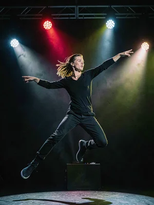 Dancer frozen mid-leap by strobe, four lights creating depth and separation