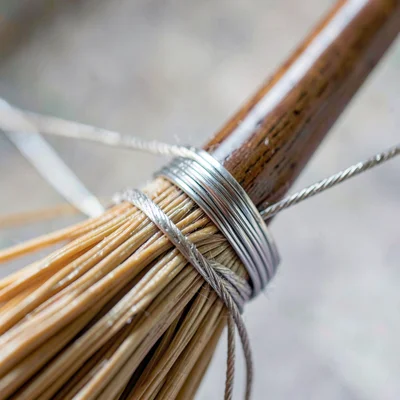 Tight texture study of a hand-wound wire wrap on a broom handle, polished sheen