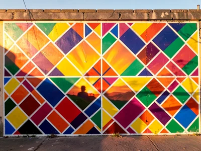 Exterior wall at sunrise — geometric pattern glowing in warm golden light