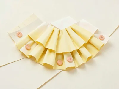 Folded cream lowpoly accordion with chunky butter-yellow bellows pleats and peac