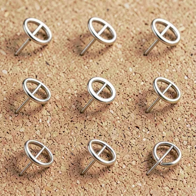 A 3x3 grid of abstract enamel-pin mockups on a soft cork backdrop, each pin in a