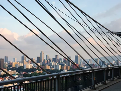 City skyline compressed behind bridge cables
