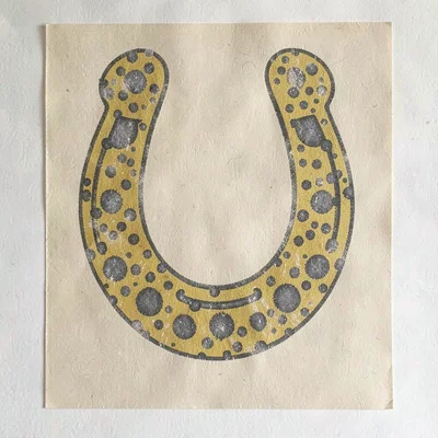 Riso poster of a stylized horseshoe in mustard and slate spot inks over warm pap