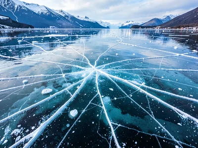 Cracks radiating through crystal-clear lake ice