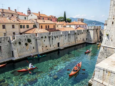 Kayakers beneath city walls