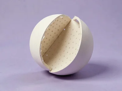 Oversized soft sphere split into perfect halves and offset slightly, revealing a
