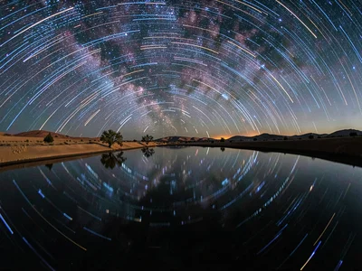 Trails reflected in still desert water