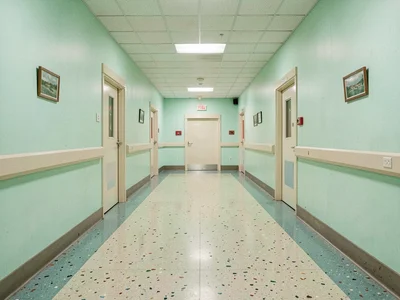 Hospital corridor with perfect bilateral symmetry, mint green walls, terrazzo fl