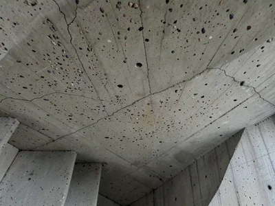 Concrete stairwell underside, spiral soffit with board-formed texture following 