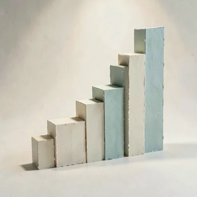 Papercraft hero of a layered paper bar chart climbing left to right, each bar a