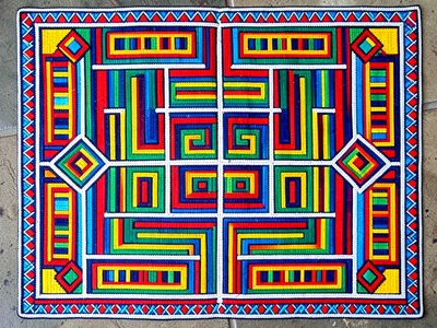 Beaded apron (jocolo) laid flat — dense geometric rows of beadwork, studio top-d