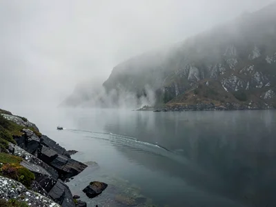 Ferry wake disappearing into mist distance