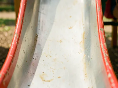 A metal slide bottom, paint worn in a smooth strip down the center from thousand