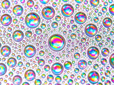Dense micro-bubble oil field on white-lit water, thousands of tiny cells creatin