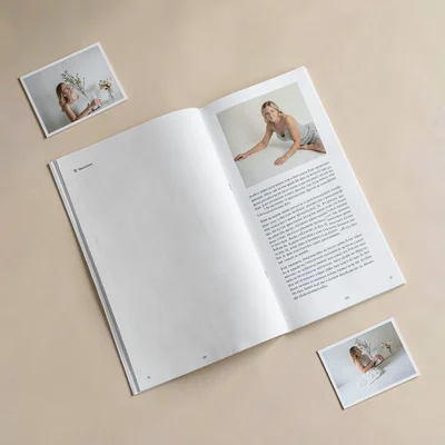 A double-page magazine spread mockup tilted at slight angle on warm-neutral grou