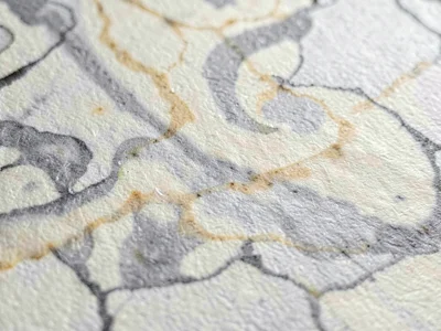 Surface of marbled paste paper showing veined swirl marbling in faded grey and c
