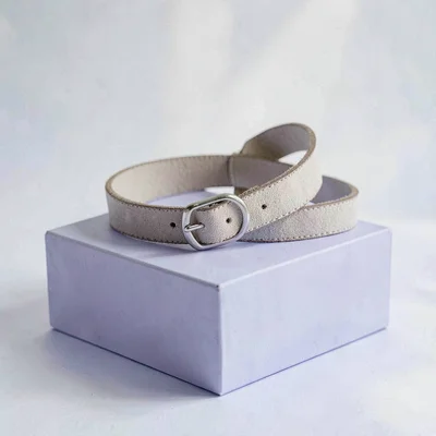 Story-format catalog of a belt threaded through itself in a soft loop on a periw