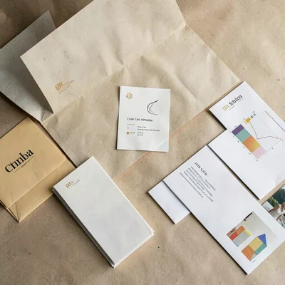 Desk-tabletop overhead view with brand collateral spread loosely across paper-te
