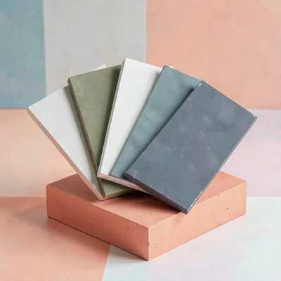 Square color-block layout of a fanned set of plaster color samples on a coral bl