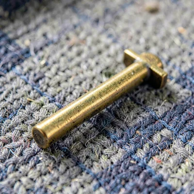Macro of a drum key on a felt cloth with brass shine