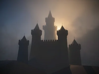 Layered castle turrets receding into a deep fog gradient with only the highest p