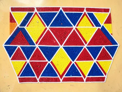 Beaded headband close-up — repeating triangular motif in blue, red, and yellow