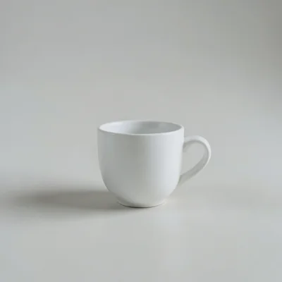 Minimalist studio photograph of a single white coffee cup on a clean neutral surface, soft diffused natural light, lots 