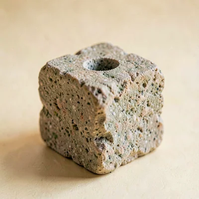 Portrait of a single sculpted stone block with a clean drilled hole near the top