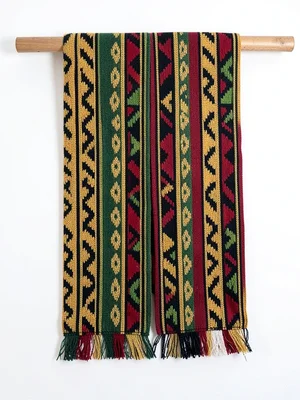 Kente bolt displayed on wooden rod — cloth hanging, both sides visible