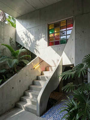 Service stairwell in utilitarian concrete, single colored-glass block in the wal