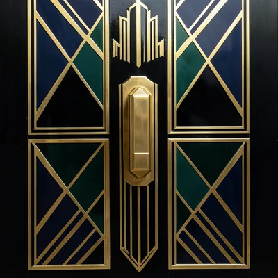 A door handle in the Deco style: a stepped geometric grip in polished brass on a