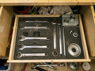Inside a mechanic's rolling tool chest top drawer viewed from above, heavy chrom