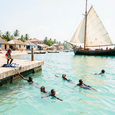Brilliant Indian Ocean noon light in Dar es Salaam, Children diving from jetty i