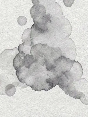 Abstract ink bloom dispersing across cold-press cotton as soft grey cloud diffus