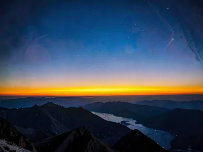 The afterglow band above mountain ridge after sun has set