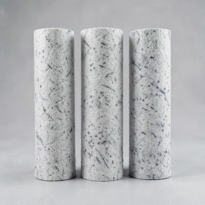 Three rolled felt sheets stood vertically on a flat surface