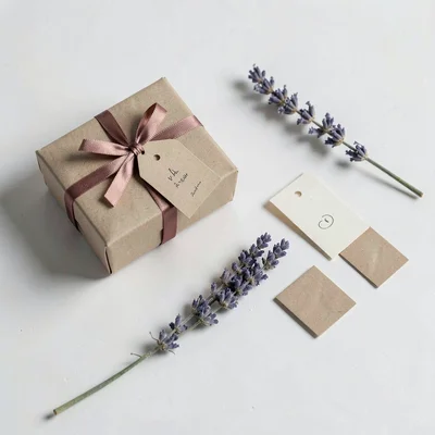 A scattered tabletop with abstract wedding-favor deliverables — small box, ribbo