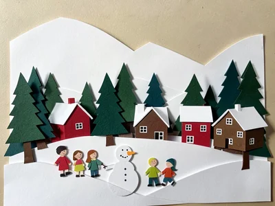A winter village: white snow hills behind, evergreen trees in dark green, red an