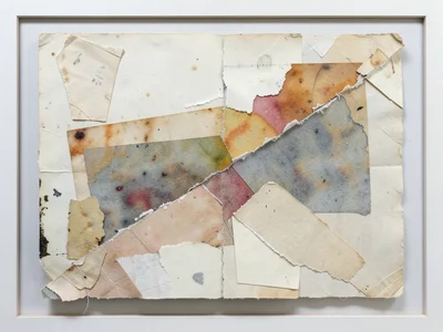 Single large tear across heavy watercolor paper, revealing colored paper beneath