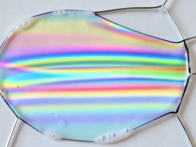 Thick soap film on cold day, slow drainage creating broad stable color bands lik