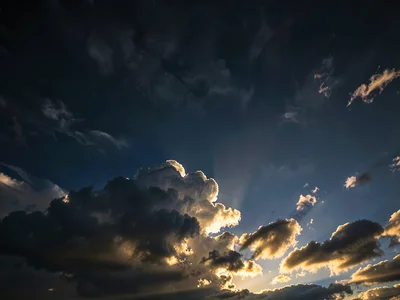Cloud illuminated from below by setting sun against dark upper sky