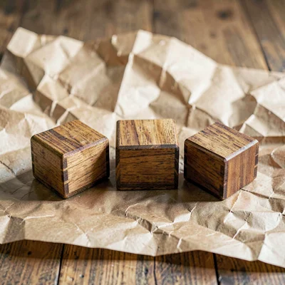 Opening spread of three small wooden boxes nesting on butcher-paper tone, hand-r