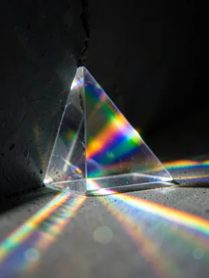 Prismatic light fanning through a crack in a dark wall, single beam splitting in