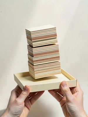 Tower of stacked cardstock plates leans precariously on a small papercraft tray