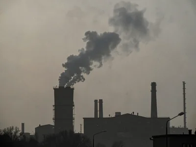Factory silhouette against polluted sky